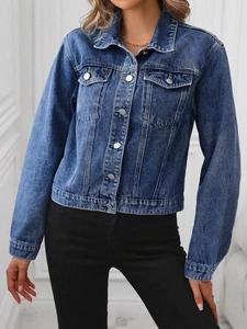 Detail of classic dark blue washed denim jacket with silver buttons and flap pockets