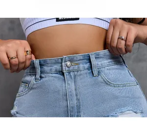 Close-up of high-waist denim shorts featuring silver metal button and frayed hem details