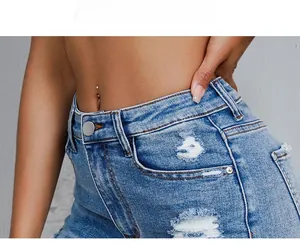 Vue detaillee du tissu denim avec dechirures usees et bouton metallique a la taille