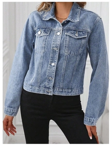 Detail shot of light blue washed denim jacket featuring metal buttons and chest pockets