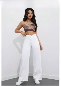 Détail du pantalon blanc taille haute à jambes larges avec un haut bandeau marron stylé