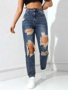 Detail of high waisted wide leg jeans with distressed ripped holes and frayed edges