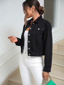 Detail of short black denim jacket with silver buttons and front flap pockets