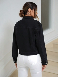 Rear view of cropped black denim jacket with metallic buttons and contrast stitching