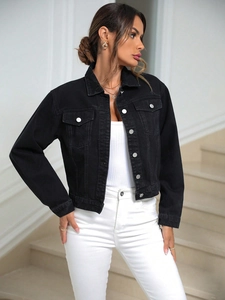 Close-up of black denim jacket with buttoned flap pockets and classic pointed collar