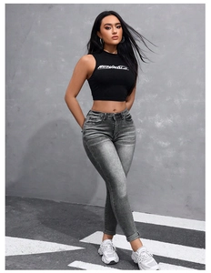 Détail d'un jean gris délavé à taille haute avec un débardeur court noir tendance