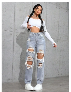 Détail de jean taille haute usé à coupe droite avec bords déchirés au style urbain chic