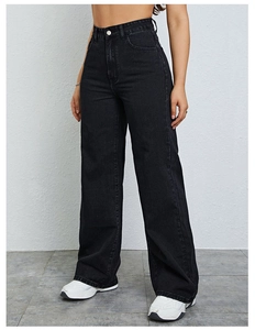 Jean noir taille haute jambe large porté par mannequin avec baskets blanches style décontracté