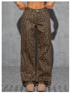 Detailed close-up of brown leopard print denim jeans with metallic silver waist button