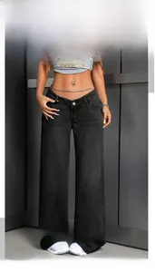 Detail view of high-waist black wide-leg jeans with metal button and curved pocket style