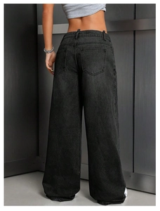 Rear view of high-waisted black wide-leg jeans showing back pockets and washed denim texture