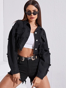Detail of black distressed denim jacket with frayed tassels and silver metal buttons
