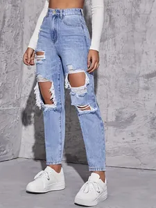 Detailed view of high waisted light blue ripped jeans with white distressed frayed edges