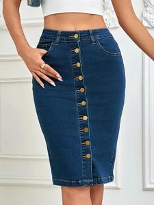 Detailed macro view of retro gold buttons on dark blue high-waisted denim skirt