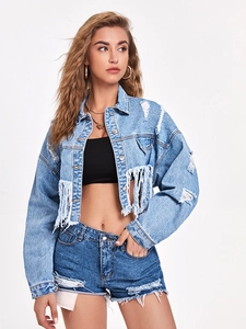 Detail shot of light blue washed denim jacket hem featuring stylish frayed fringe accents