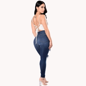 Side view of dark blue high waisted skinny jeans with distressed ripped detailing