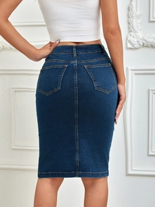Detail view of the back pockets and yellow stitching on dark blue denim skirt