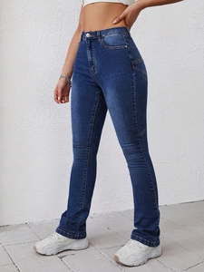 Detail of high waisted flared denim jeans with washed finish and unique side stitching