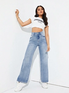 Detail of high waisted wide leg jeans in light blue wash denim with straight cut design