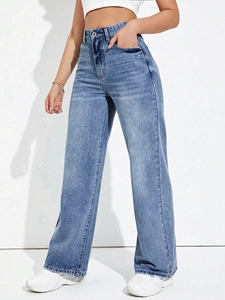 Detail of high waist denim jeans showing metal button, zipper, and faded wash texture