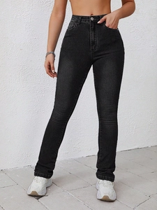 Close-up of black high-waisted skinny jeans with metal button and pocket details