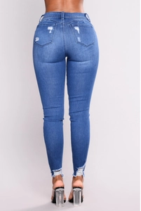 Dettaglio posteriore di jeans skinny blu a vita alta con tasche strappate ed usurate