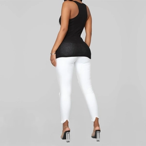 Rear view of women's black ribbed racerback tank top paired with white jeans