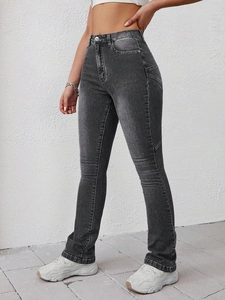 Detail of high-waisted flared jeans with vintage faded wash and metallic button detail