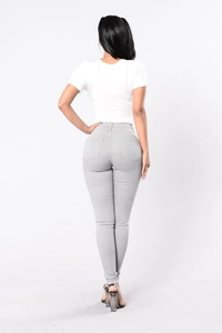 Rear view of slim fit high waisted light grey stretch denim pants for women