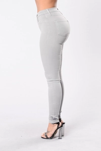 Detail view of light grey slim fit high waisted denim jeans showing back pocket and curve