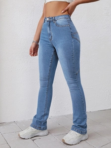 Detail of high waisted light blue flare jeans with unique diagonal seam stitching accents