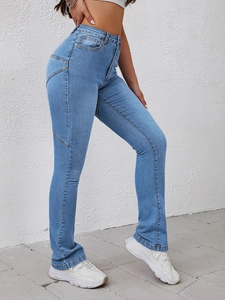 Detail of high waisted flared jeans with V-shaped decorative stitching on the side