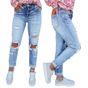 Close-up of light blue distressed skinny jeans with heavy knee rips and frayed details