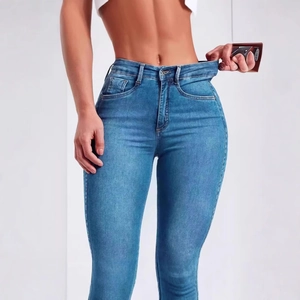 Détail montrant la taille haute élastique et l'effet gainant du jean slim bleu
