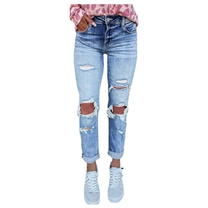 Detail shot of distressed rips and rolled hem on light blue high-waisted denim jeans