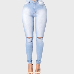 Détail du jean skinny taille haute bleu clair avec déchirures aux genoux