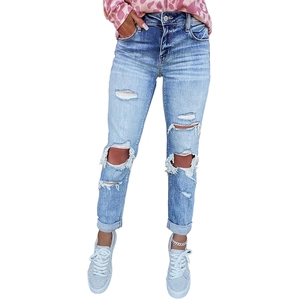 Close-up of light blue ripped jeans featuring distressed knees and cuffed hems