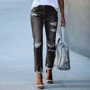Détails de déchirures et ourlet effiloché sur un jean gris anthracite ajusté