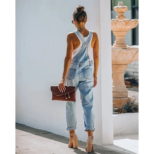 Back view of light blue denim overalls with criss-cross straps and cuffed hems details