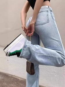 Women's light blue high-waisted straight jeans paired with stylish platform sneakers