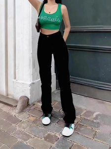 Women's high waisted black straight jeans and green halter top for a street style look