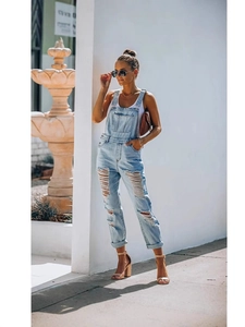 Women's light blue distressed denim overalls with ripped details and slim fit style