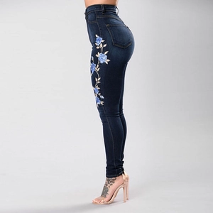 Jean skinny bleu foncé à taille haute avec broderies florales bleues sur le côté