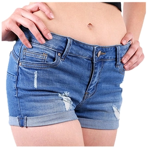 Detail of blue denim shorts showing washed texture with distressed ripped effect and rolled hem