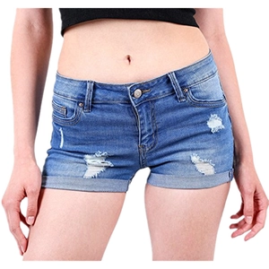 Detail view of denim shorts showing distressed holes and folded cuffs on blue jeans