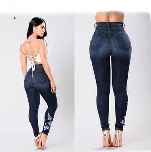 Gros plan détaillé sur la broderie florale bleue du jean skinny bleu foncé taille haute