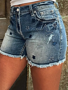 Detail of frayed denim shorts with star embroidery and distressed vintage wash