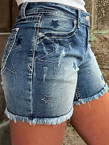 Close-up of high waist denim shorts with star embroidery details and frayed raw hem edge