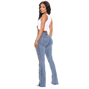 Women's high waist flared jeans with side lace-up eyelets and fringe hem in blue wash