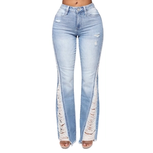 Detail of light blue flared jeans with heavy distressing and frayed fringe on legs